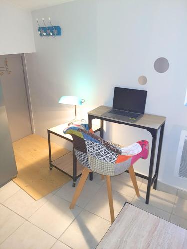 a desk and a chair with a laptop on it at ღ Le cocon Montilien - Confortable T2 avec Wifi in Montélimar
