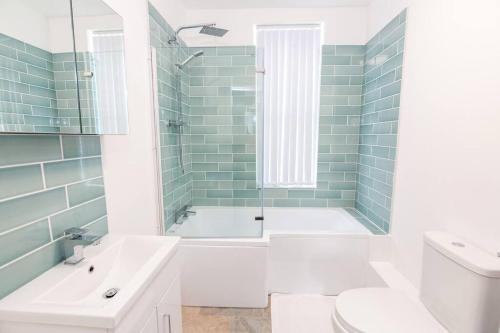 ein Badezimmer mit einer Badewanne, einem WC und einem Waschbecken in der Unterkunft 4 bedroom house, 5 double beds in Leeds