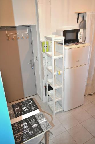 a small kitchen with a refrigerator and a microwave at ღ Le cocon Montilien - Confortable T2 avec Wifi in Montélimar