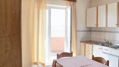 kuchnia ze stołem i oknem z widokiem w obiekcie Cosy Apartment in Ražanac 34 m² + View w Ražancu