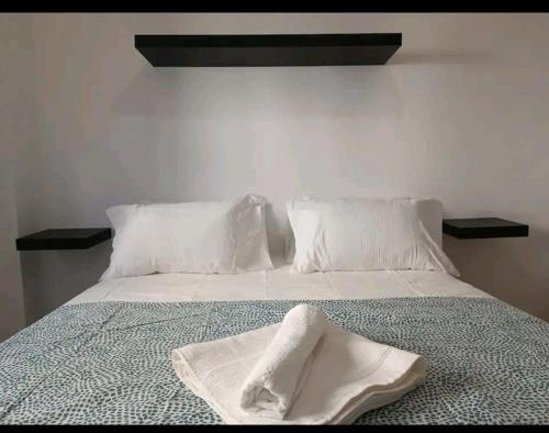 a white bed with two white towels on it at luminosa habitación en vallecas in Madrid