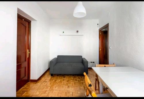 uma sala de estar com um sofá e uma mesa em luminosa habitación en vallecas em Madrid