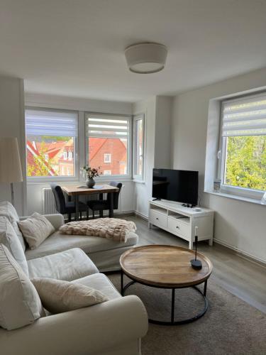 - un salon avec un canapé blanc et une table dans l'établissement Ferienwohnung Altstadtblick, à Emden