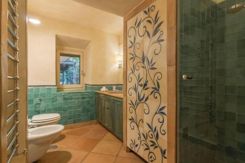 a bathroom with a toilet and a glass shower at Villaflair - Sea View Porto Ercole in Porto Ercole