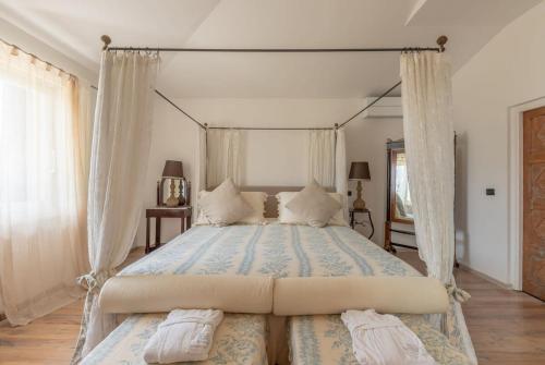 a bedroom with a canopy bed with two pillows at Villaflair - Villa Saturnia in Saturnia