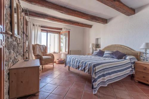 ein Schlafzimmer mit einem Bett und einem Stuhl in einem Zimmer in der Unterkunft Villaflair - Feniglia Beach House in Cala Galera