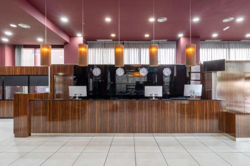 a lobby with a bar with clocks on the wall at Exe Convention Plaza Madrid in Madrid