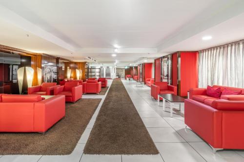 a waiting room with red chairs and tables at Exe Convention Plaza Madrid in Madrid