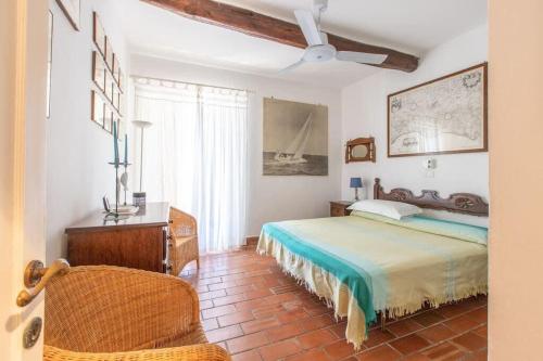 una camera con letto, scrivania e sedia di Villaflair - Villa Sbarcatello a Porto Santo Stefano