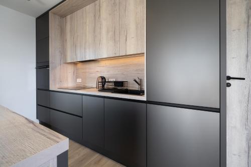a kitchen with black and white cabinets and a sink at Silent Mountain in Bukowina Tatrzańska