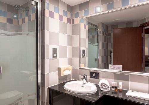 a bathroom with a sink and a mirror at Thatchers Bar & Restaurant in East Horsley