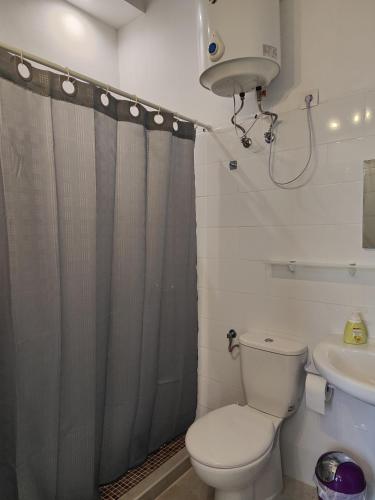 a bathroom with a toilet and a sink and a shower curtain at Charming studio in Tazacorte in Tazacorte
