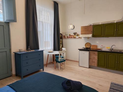 uma cozinha com armários verdes e uma mesa num quarto em Charming studio in Tazacorte em Tazacorte