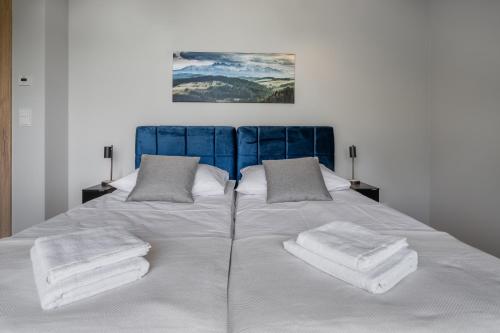 a large white bed with towels on top of it at Silent Mountain in Bukowina Tatrzańska
