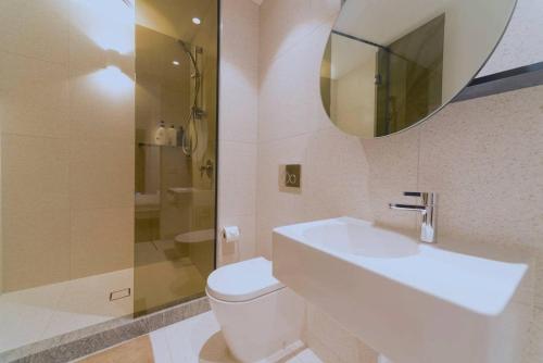 ein Badezimmer mit einem Waschbecken, einem WC und einem Spiegel in der Unterkunft Fawkner Residence 1B2B condo Smart TV in Melbourne