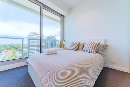 a bedroom with a bed and a large window at Fawkner Apartment Bay-view 4 in Melbourne