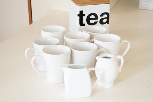 a group of white cups sitting next to a tea box at Welcome to Villa Cristy 3-BR 3 5-WC in the La Floresta area in Ajijic