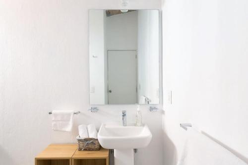 a white bathroom with a sink and a mirror at Welcome to Villa Cristy 3-BR 3 5-WC in the La Floresta area in Ajijic