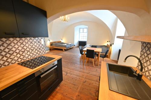 a kitchen with a stove and a living room at Zámecká lesovna in Valeč