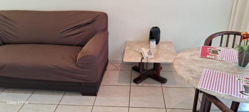 a living room with a couch and a table at AGRISHOW BASSANO VACCARINI Flat ULTIMAS UNIDADES in Ribeirão Preto