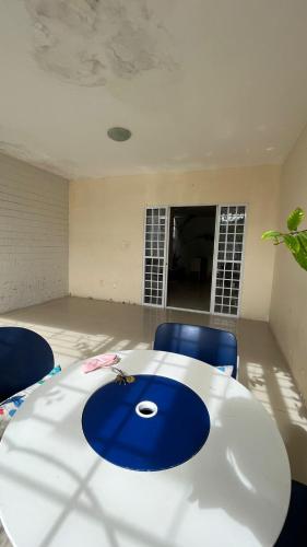 Habitación con mesa blanca y 2 sillas azules en Casa Olinda en Olinda