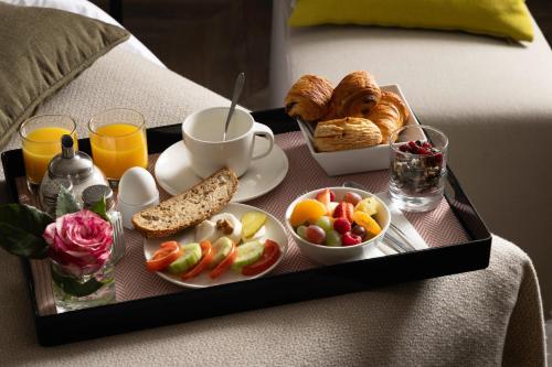 a tray of breakfast food on a bed at Hotel D Geneva in Geneva