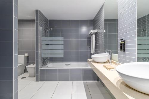 a bathroom with a tub and a sink and a toilet at Exe Convention Plaza Madrid in Madrid