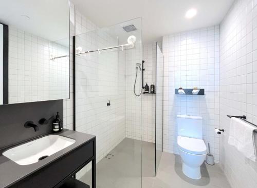a bathroom with a toilet and a sink and a shower at Camberwell Village ONE APT Smart TV in Melbourne