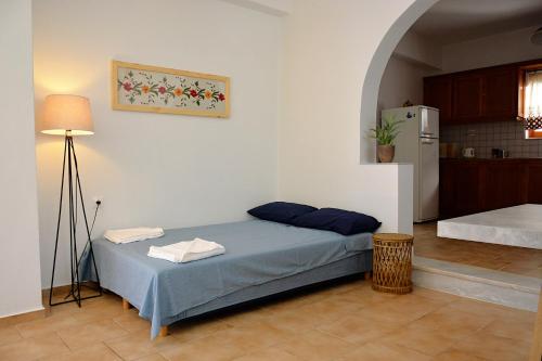 een slaapkamer met een bed met een lamp en een keuken bij Vori`s blue door country house in Vóroi