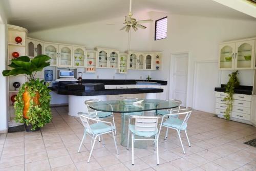 a kitchen with a glass table and chairs at Paradis Villa breach front ocean view in Manzanillo