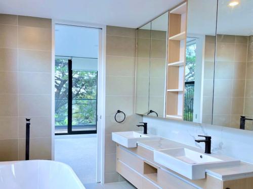 uma casa de banho com 2 lavatórios e um espelho grande em Grandeur Innercity Townhouse em Melbourne
