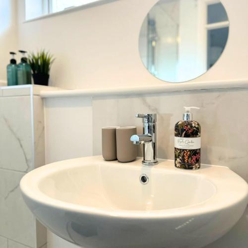 a bathroom sink with a bottle of soap on it at Newly refurbished 2 bed in Thame in Thame