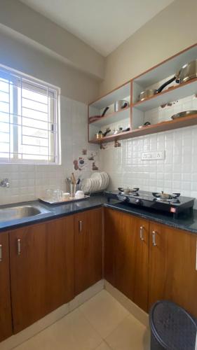 a kitchen with wooden cabinets and a sink at M premium executive apartment in Bangalore