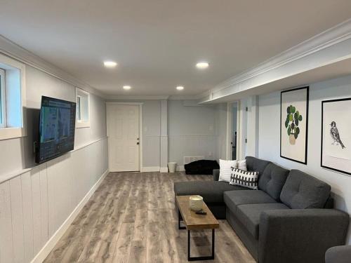 a living room with a couch and a tv at River View House Basement in Kamloops