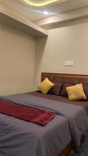 a bedroom with a bed with yellow and red pillows at M premium executive apartment in Bangalore