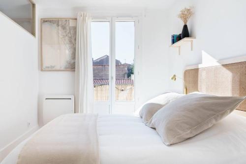 une chambre blanche avec un lit et une fenêtre dans l'établissement Appartement terrasse au cœur d'Aix-en-Provence #2, à Aix-en-Provence
