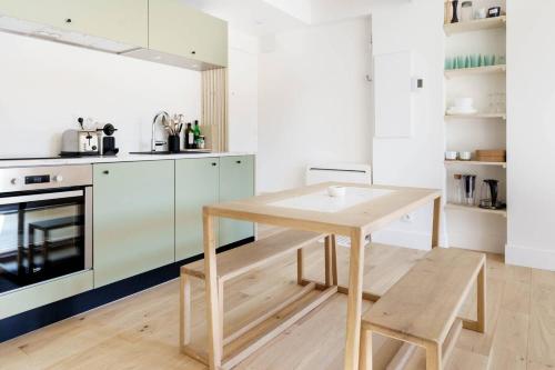 - une cuisine avec une table et un banc en bois dans l'établissement Appartement terrasse au cœur d'Aix-en-Provence #2, à Aix-en-Provence