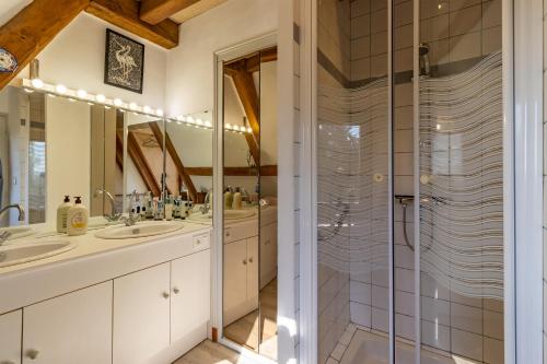 une salle de bain avec deux lavabos et une douche dans l'établissement Le Pigeonnier de Sinzelle, à Saint-Cyprien