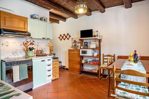a kitchen with a table and a dining room at La casa di Ketty in Bieno