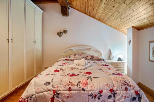 a bedroom with a bed with a floral bedspread at La casa di Ketty in Bieno