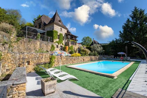 un domaine avec une piscine en face d'un bâtiment dans l'établissement Le Pigeonnier de Sinzelle, à Saint-Cyprien