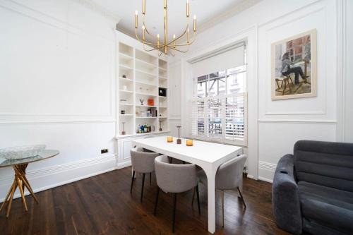 uma sala de estar com uma mesa branca e cadeiras em Stylish 2-Bed Flat in London em Londres