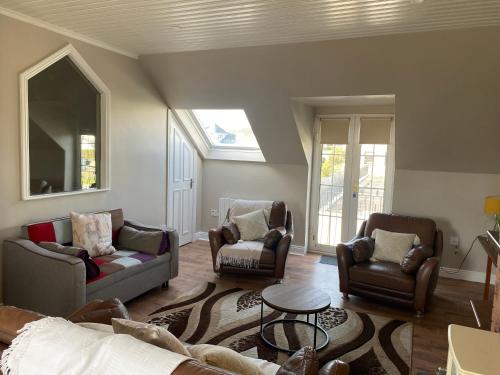 sala de estar con 2 sillas y sofá en Lahinch Central 3-Bed Retreat, en Lahinch