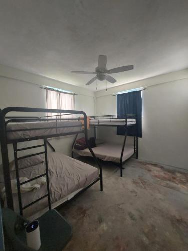 two bunk beds in a room with a ceiling fan at Hacienda Familiar en Hato Mayor del Rey 