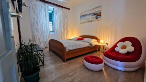 a bedroom with a bed and a red chair at Urban Lights Hideaway in Šibenik