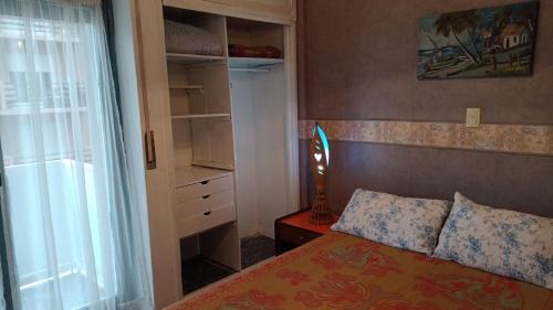 Dormitorio pequeño con cama y armario en Departamento Manamar en Mar del Plata