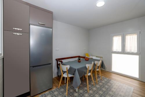 a kitchen with a table with chairs and a refrigerator at Precioso y espacioso piso ideal para familias. in El Burgo de Osma