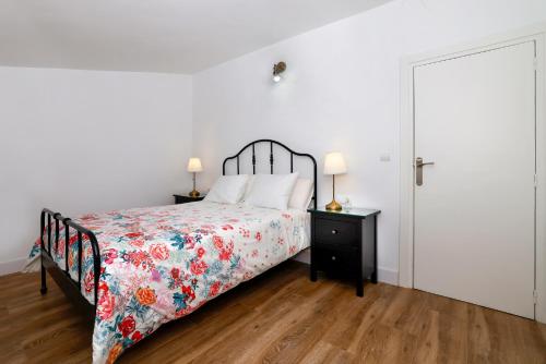 a bedroom with a bed with a floral bedspread and a door at Precioso y espacioso piso ideal para familias. in El Burgo de Osma