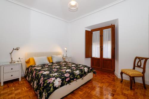 a bedroom with a bed and a chair and a window at Precioso y espacioso piso ideal para familias. in El Burgo de Osma