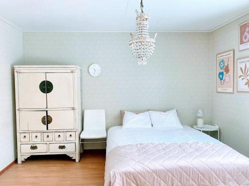 a bedroom with a bed and a dresser and a chandelier at Expe Finland in Porvoo